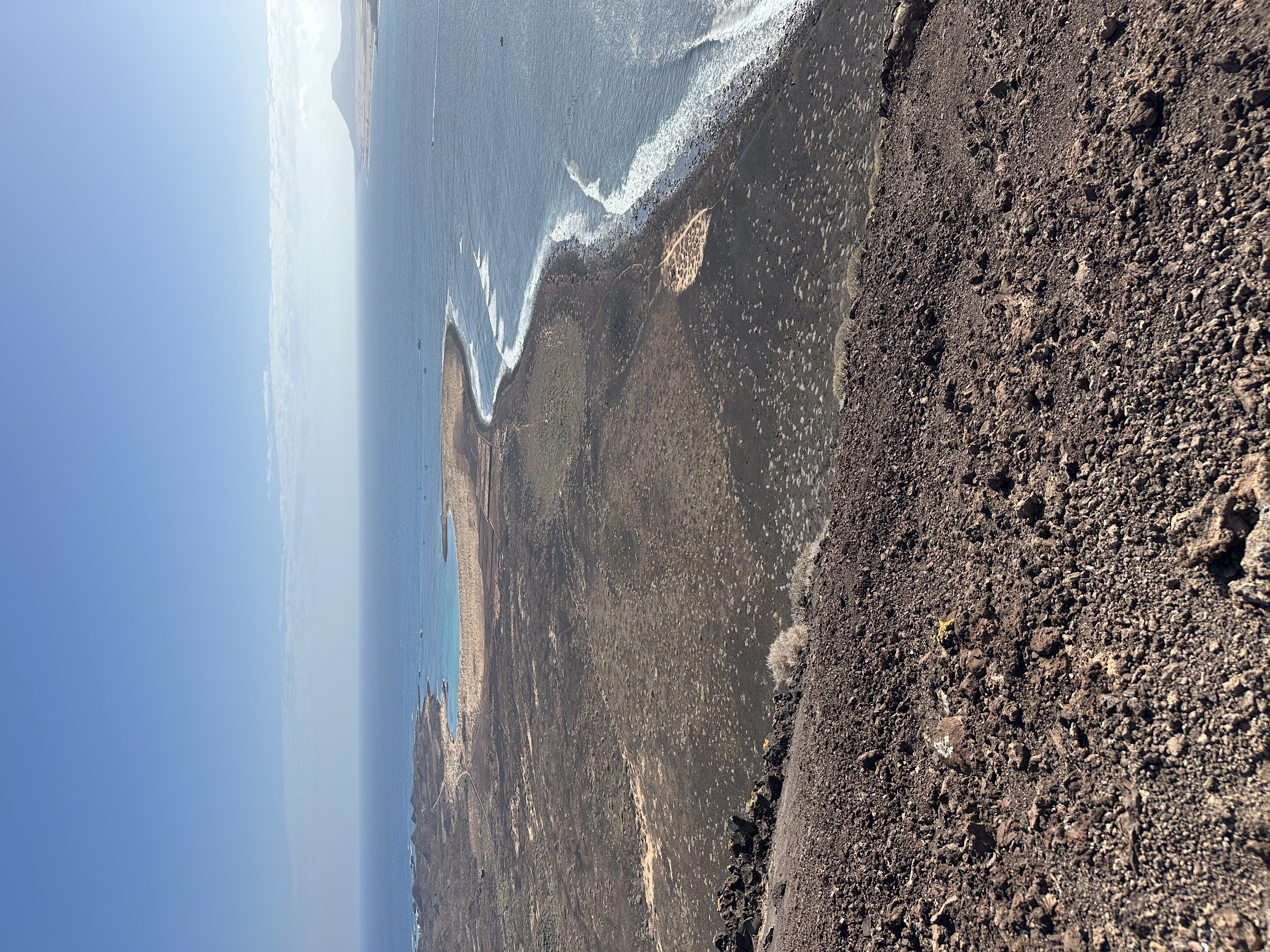 Dramatic view down the volcanic cliffs of Isla de Lobos to the waves breaking on the black rock shore below