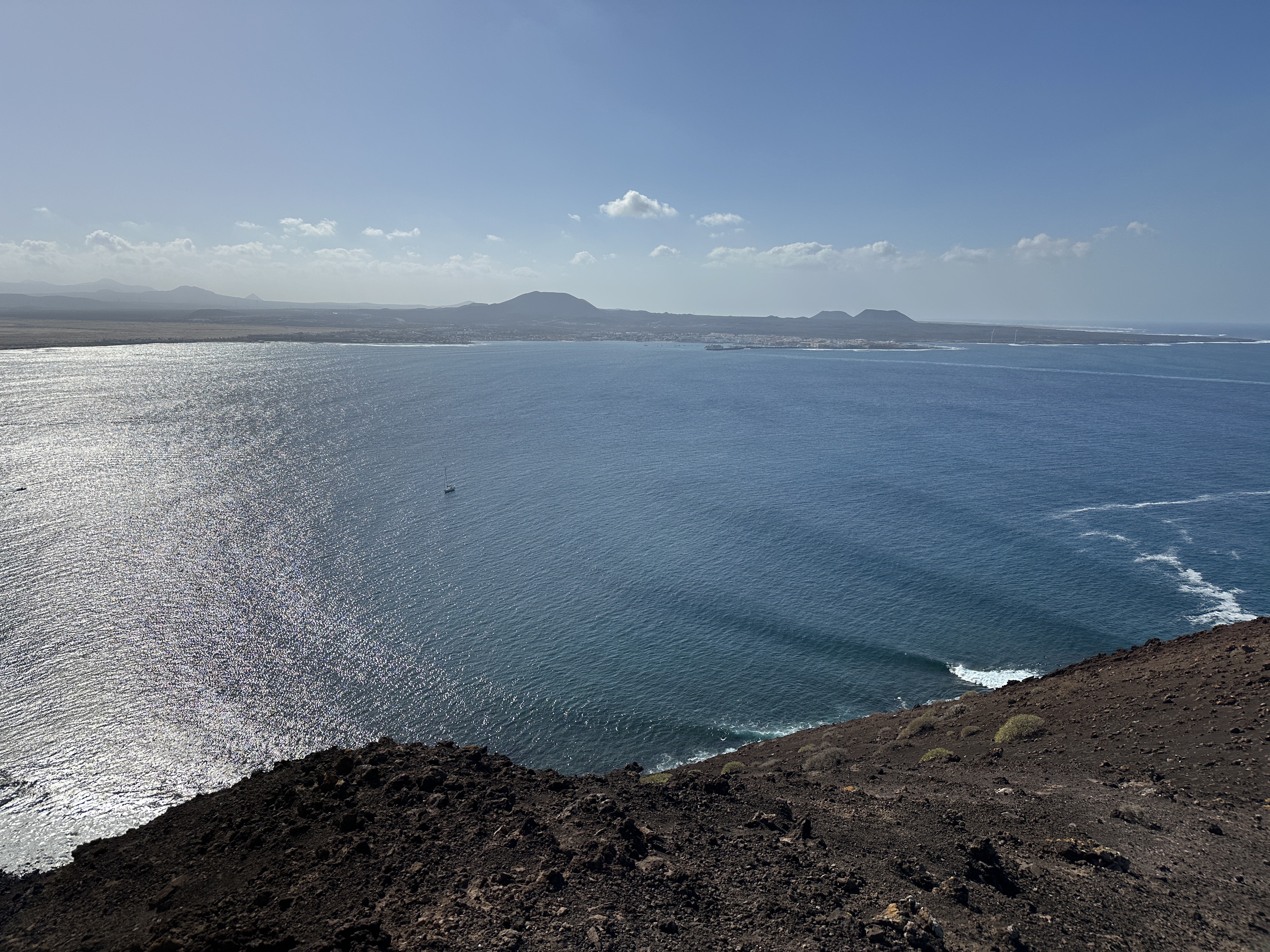 Panoramic view from Isla de Lobos looking across the strait toward Corralejo and Fuerteventura under a clear blue sky