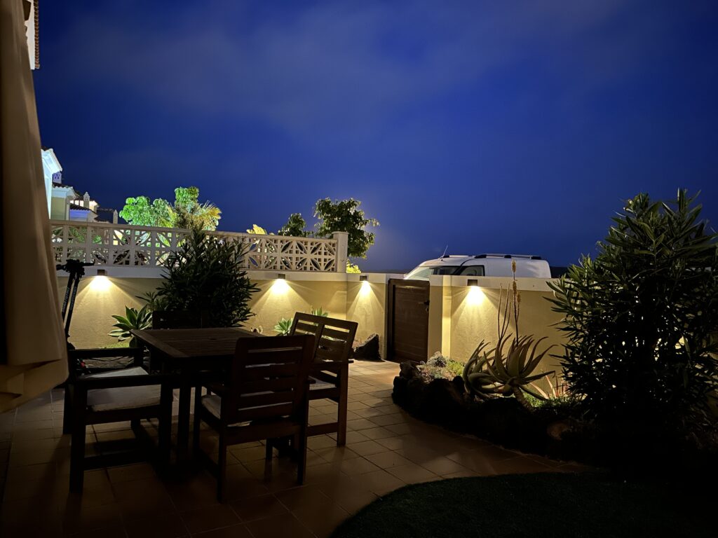 Covered terrace by night — dining area with warm ambient lighting